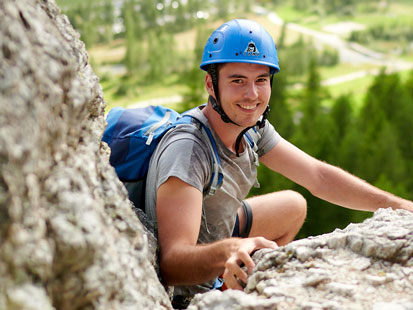 Climber with helmet and backpack in full wall